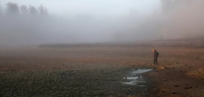 A man walks across the bottom of a dried lake in Petorca, Chile.