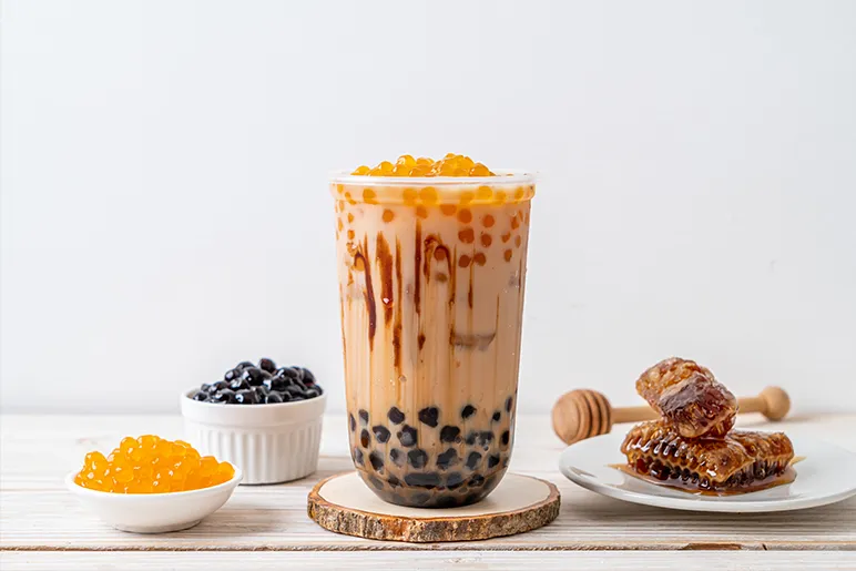 a container of bubble tea  with some natural honey