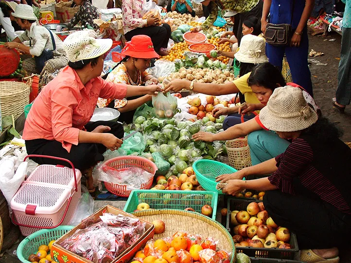 Women selling and buying at street market